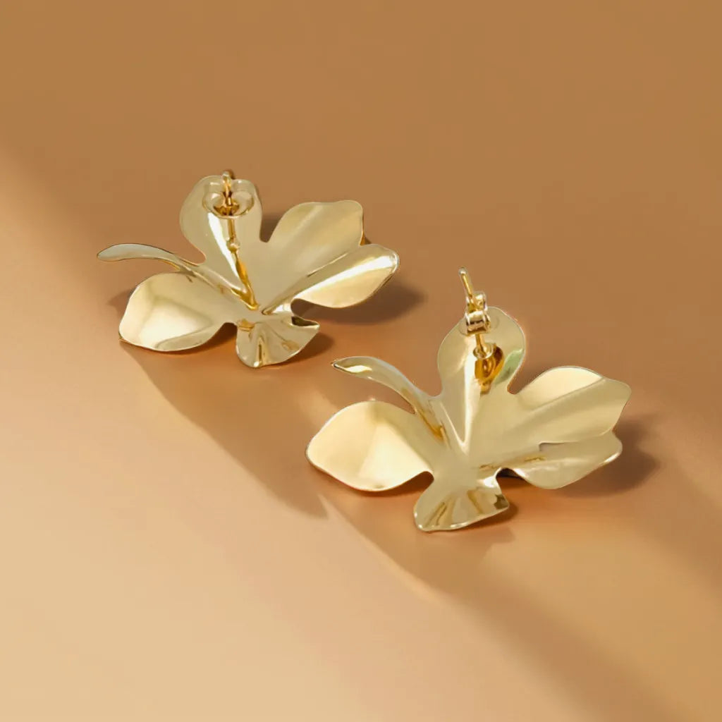 Petal-shaped gold earrings for women (37x32mm) displayed on satin background
Close-up of floral-inspired gold earrings with textured finish
Model wearing elegant women gold earrings with pulled-back hairstyle