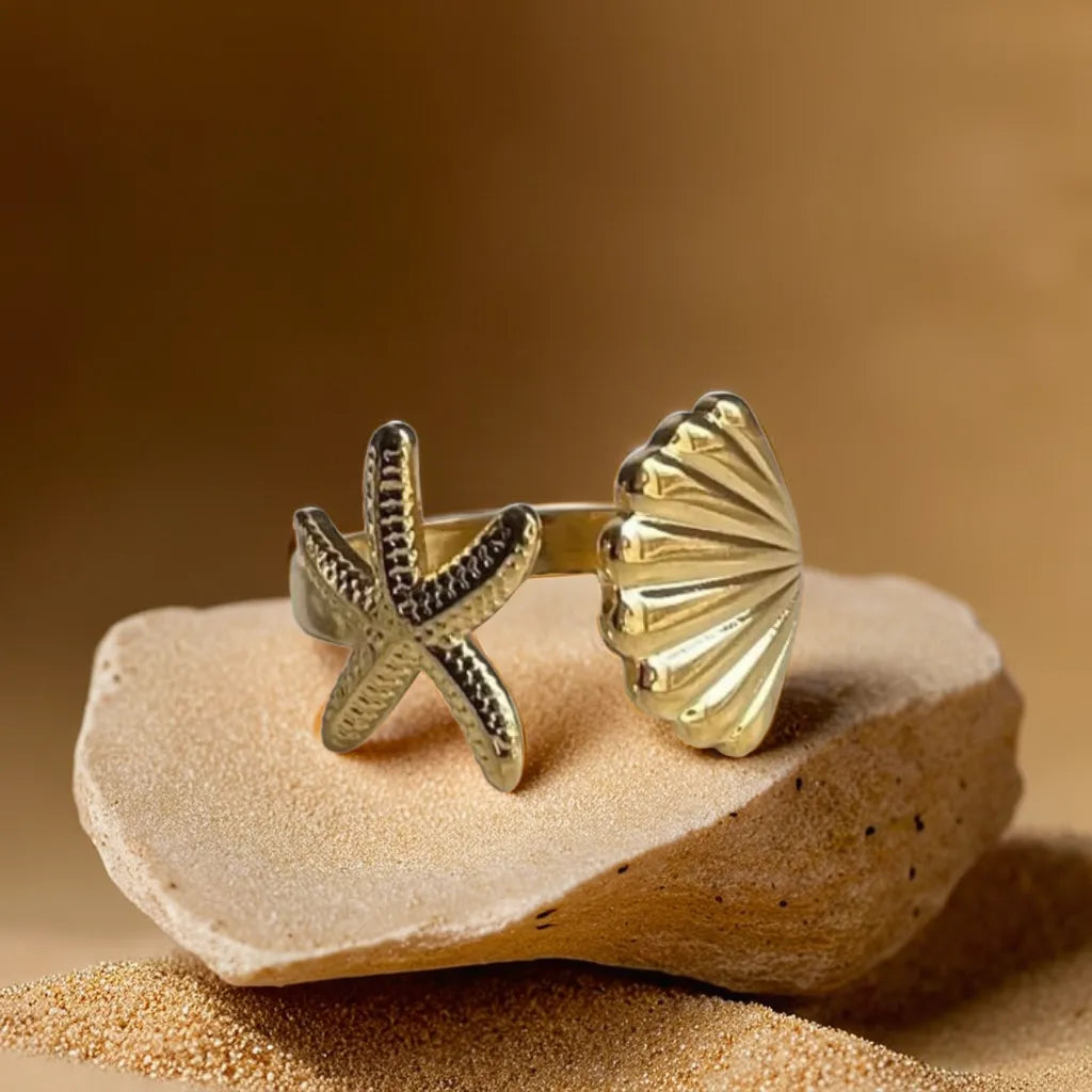 Women gold ring with starfish and shell design – front view
Gold plated ring for woman – side profile of coastal motif
Anneau Trésor Marin – adjustable gold ring with beach-inspired details
Gold ring for woman – ocean-themed jewelry on hand m