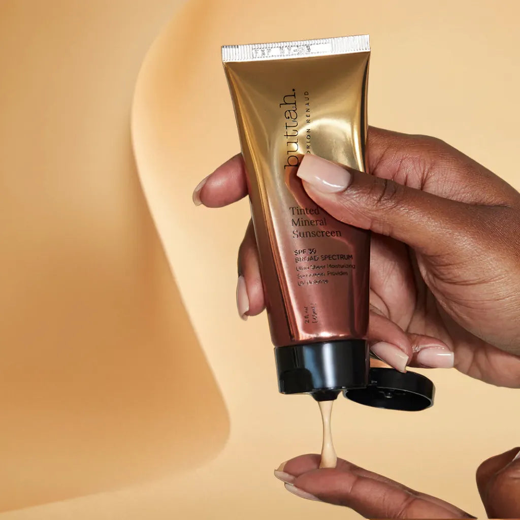 Invisible tinted sunscreen swatch on dark skin
SPF bottle with pump cap on neutral background
Sunscreen application on melanin-rich complexion
Matte finish skin after SPF application