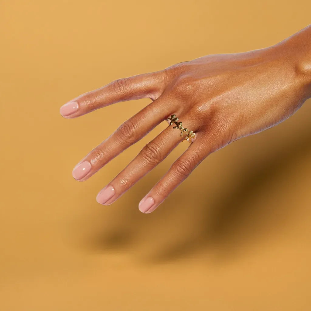 Gold bow ring with delicate triple-knot design close-up view
Adjustable bow ring shown on hand for sizing reference
Gold ring for women styled with other rings for a layered look
Elegant gold bow ring detail highlighting the 18k plating