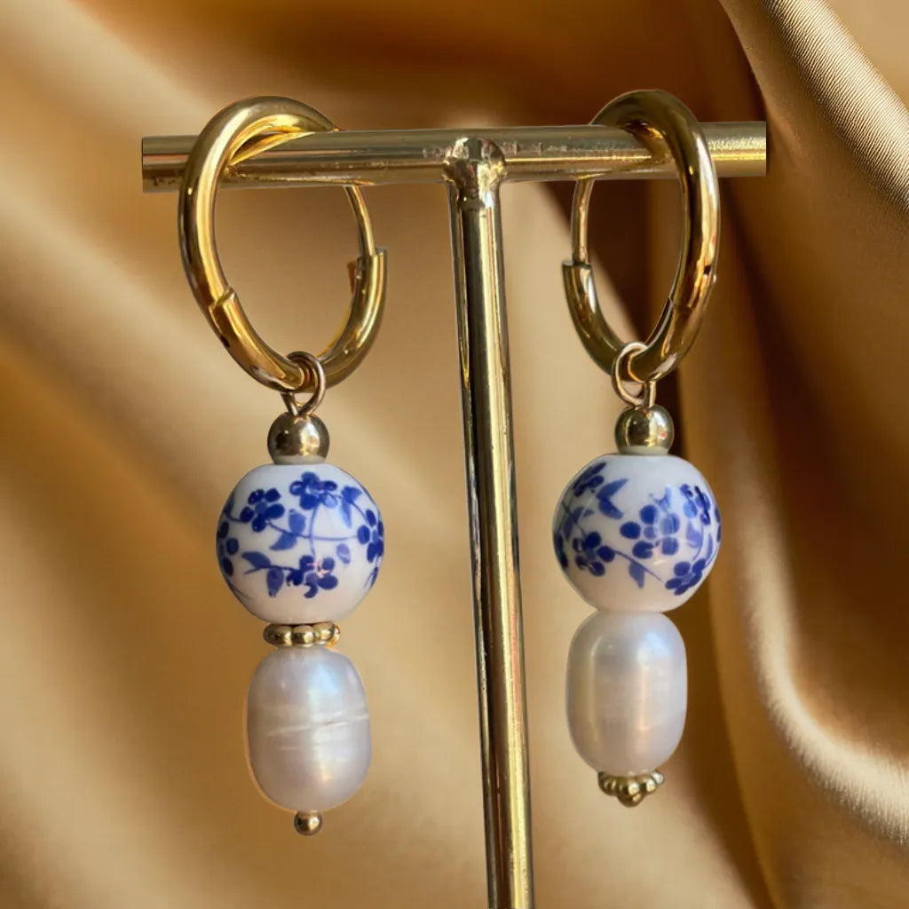 gold earrings women – Mediterranean tile pearl huggie hoops
18k gold plated huggie hoops with pearl charm
Mediterranean style gold earrings close-up
gold earrings for woman – tile design with pearl dangle