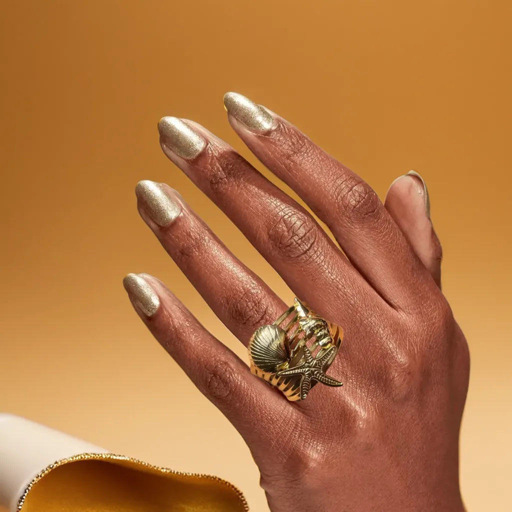 Chunky gold ocean-inspired ring for women – top view
Bague dorée femme silhouette ondulée – side profile
Adjustable 18k gold plated ring with ocean curves
Bold woman gold ring – worn with minimalist outfit