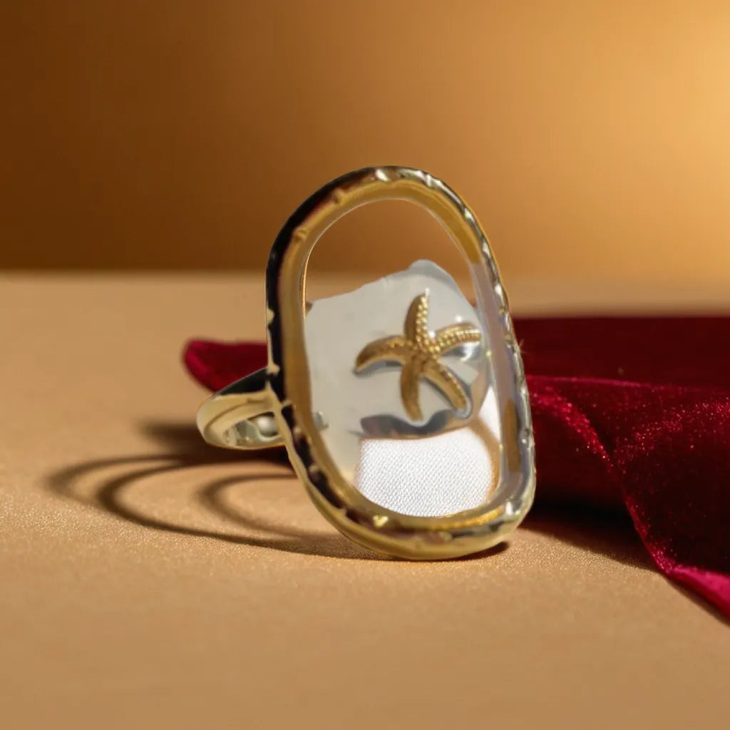 Woman Gold Ring with Starfish – Anneau Océan Cristallin
This 18K gold-plated starfish ring blends beachside charm with refined elegance. Adjustable, lightweight, and perfect for summer-inspired looks.
Gold starfish ring for women – close-up of gold plated design
Ocean-inspired ring with transparent resin – woman gold ring coastal style
Adjustable beach-themed ring – gold ring for woman with starfish motif
Anneau Océan Cristallin on hand – lightweight summer ring