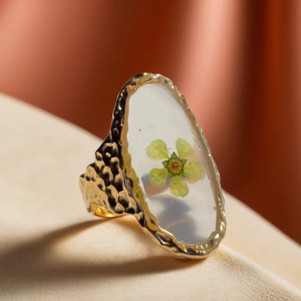 Woman Gold Ring with Green Pressed Flower – Bague Fleur Verte Éternelle
Discover a woman gold ring with real green flower preserved in 18K gold plating. Romantic, adjustable, and perfect for elegant nature lovers.
Gold plated ring with green pressed flower – woman gold ring top view
Side angle of gold ring with real flower – botanical gold plated ring
Hand wearing floral gold ring – gold ring for woman nature-inspired
Adjustable band detail of gold ring – delicate and romantic women’s ring