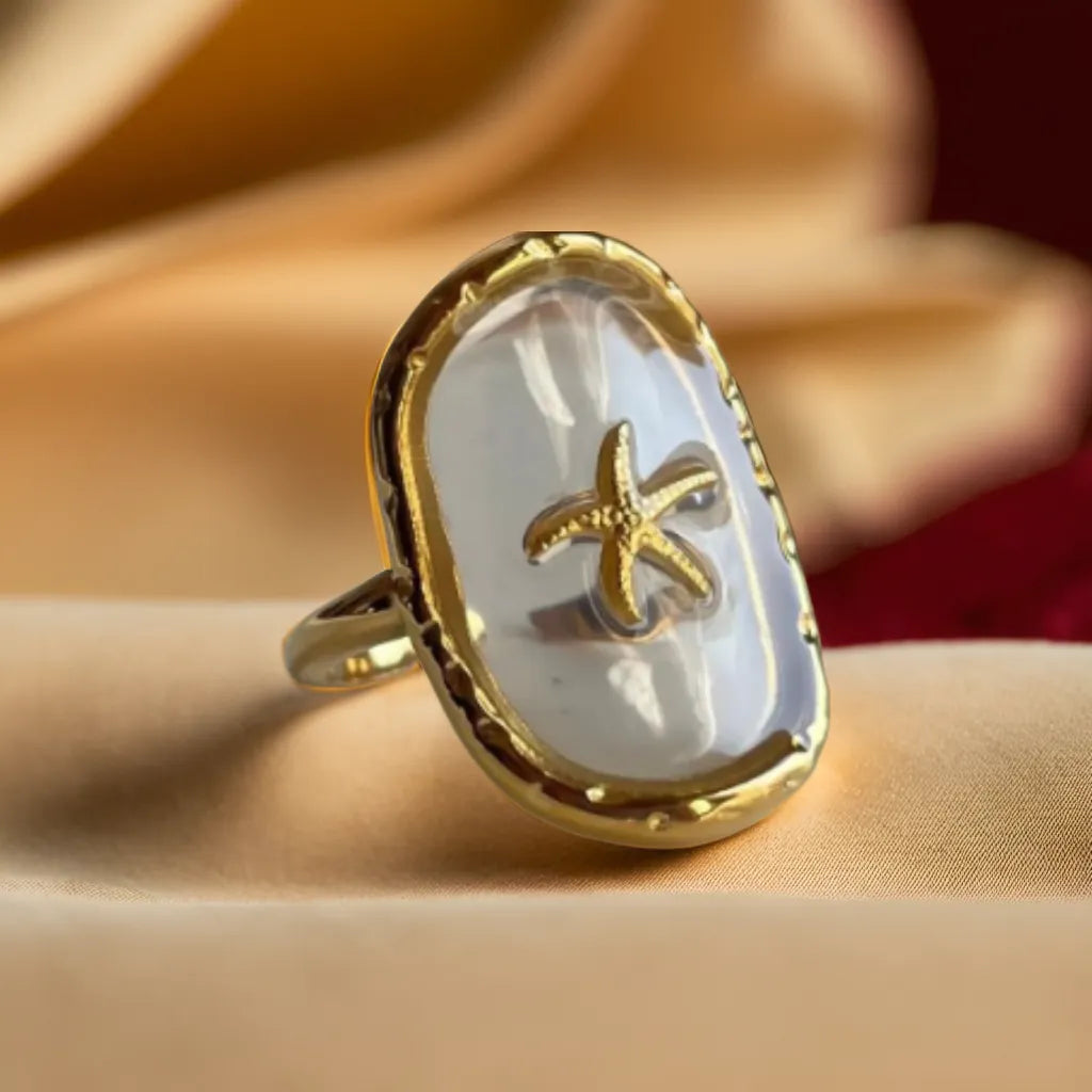 Woman Gold Ring with Starfish – Anneau Océan Cristallin
This 18K gold-plated starfish ring blends beachside charm with refined elegance. Adjustable, lightweight, and perfect for summer-inspired looks.
Gold starfish ring for women – close-up of gold plated design
Ocean-inspired ring with transparent resin – woman gold ring coastal style
Adjustable beach-themed ring – gold ring for woman with starfish motif
Anneau Océan Cristallin on hand – lightweight summer ring