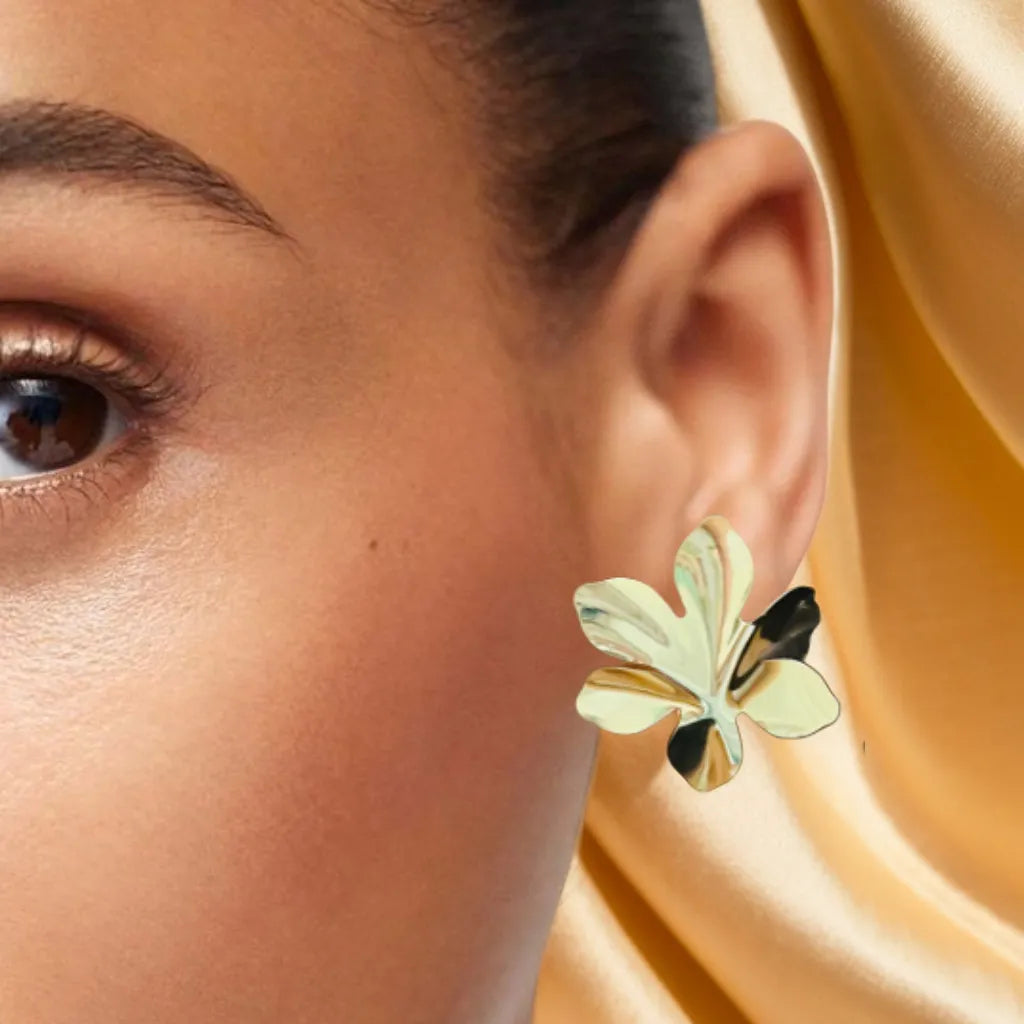Petal-shaped gold earrings for women (37x32mm) displayed on satin background
Close-up of floral-inspired gold earrings with textured finish
Model wearing elegant women gold earrings with pulled-back hairstyle
