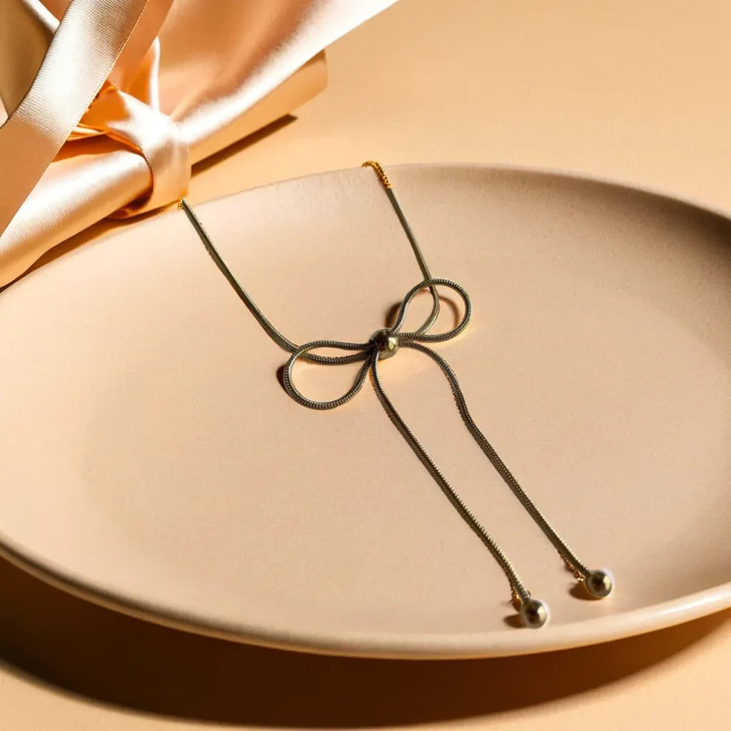 Necklace with a bow on a beige plate