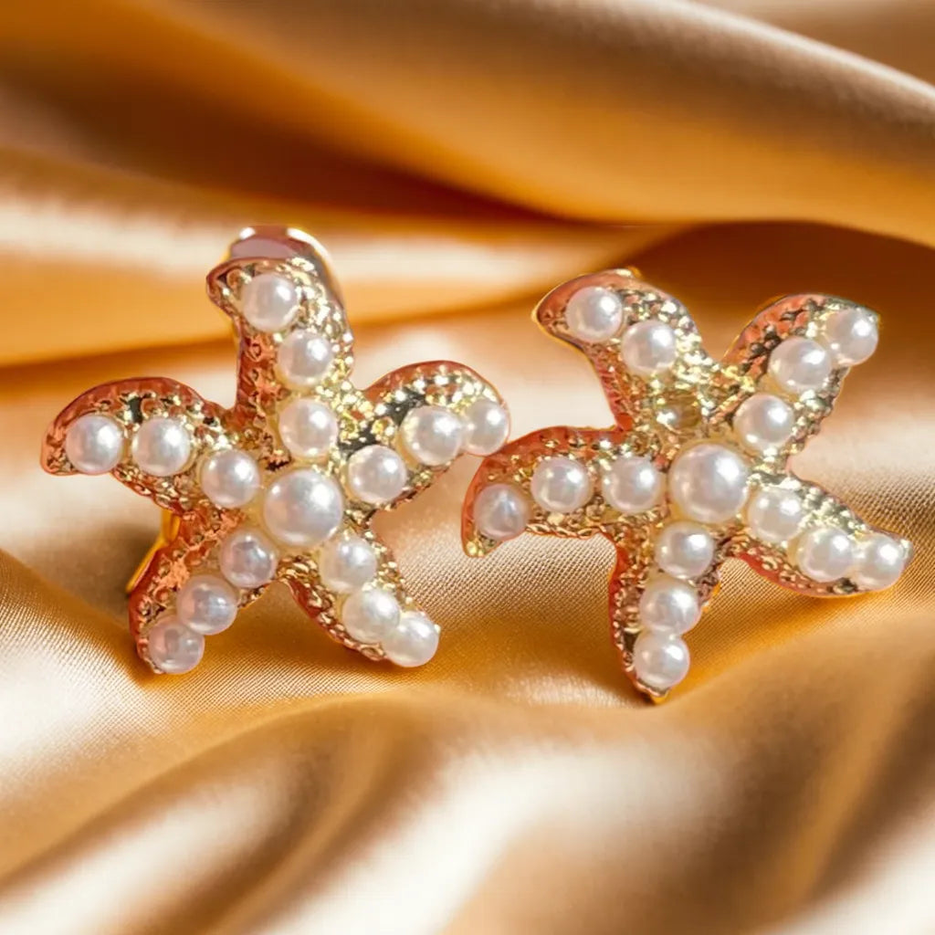 gold earrings women pearl starfish design

18k gold plated starfish earrings with pearls

tiny starfish earrings for woman close up

ocean-inspired pearl gold earrings women