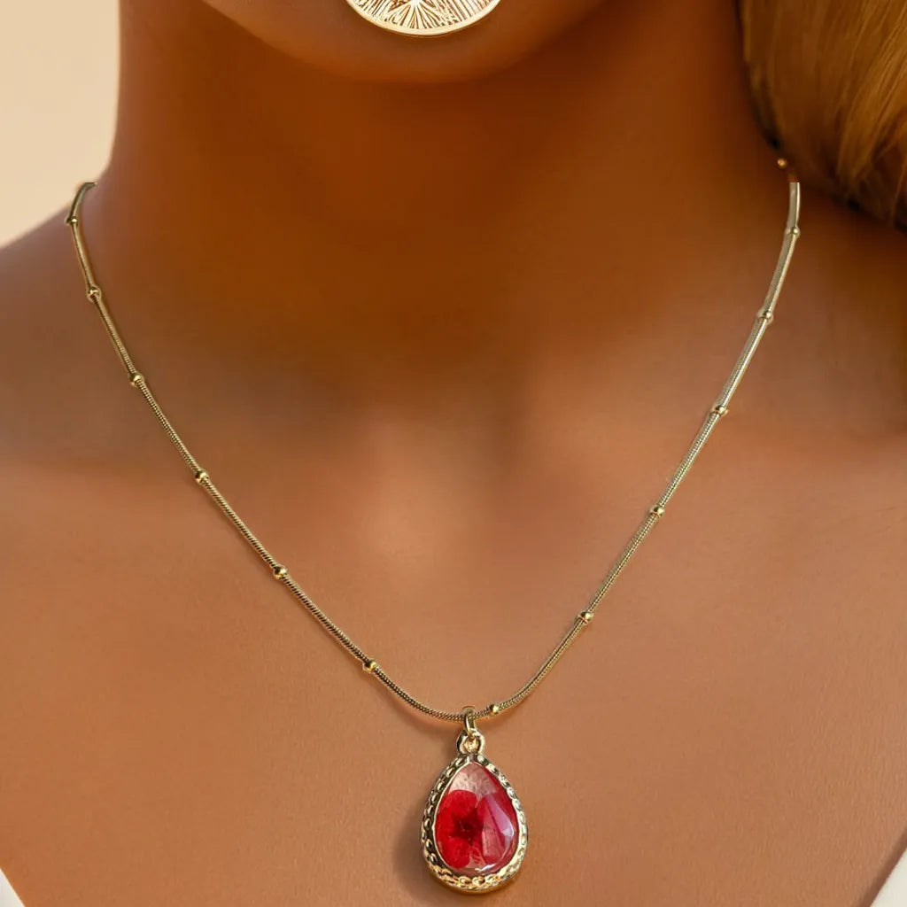 Red pressed flower gold necklace – close-up

18k gold plated women’s necklace – pendant detail

Nature-inspired gold necklace for women – adjustable chain view