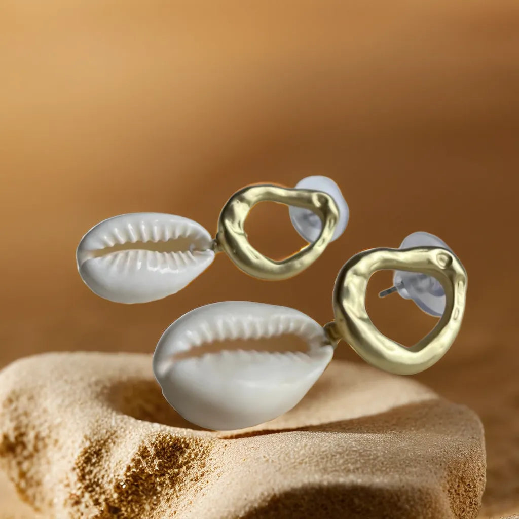 Women Gold Earrings – Cowrie Shell Hoops | Créoles Trésor de l’Océan

Embrace seaside charm with these women gold earrings featuring real cowrie shells and 18K gold plating. Lightweight, elegant, and made to shine.

Women gold earrings with cowrie shell – close-up on white background

Cowrie shell hoop earrings gold plated – coastal style jewelry

Créoles Trésor de l’Océan – gold shell earrings in natural light

Boho chic gold earrings for woman – beach-inspired design