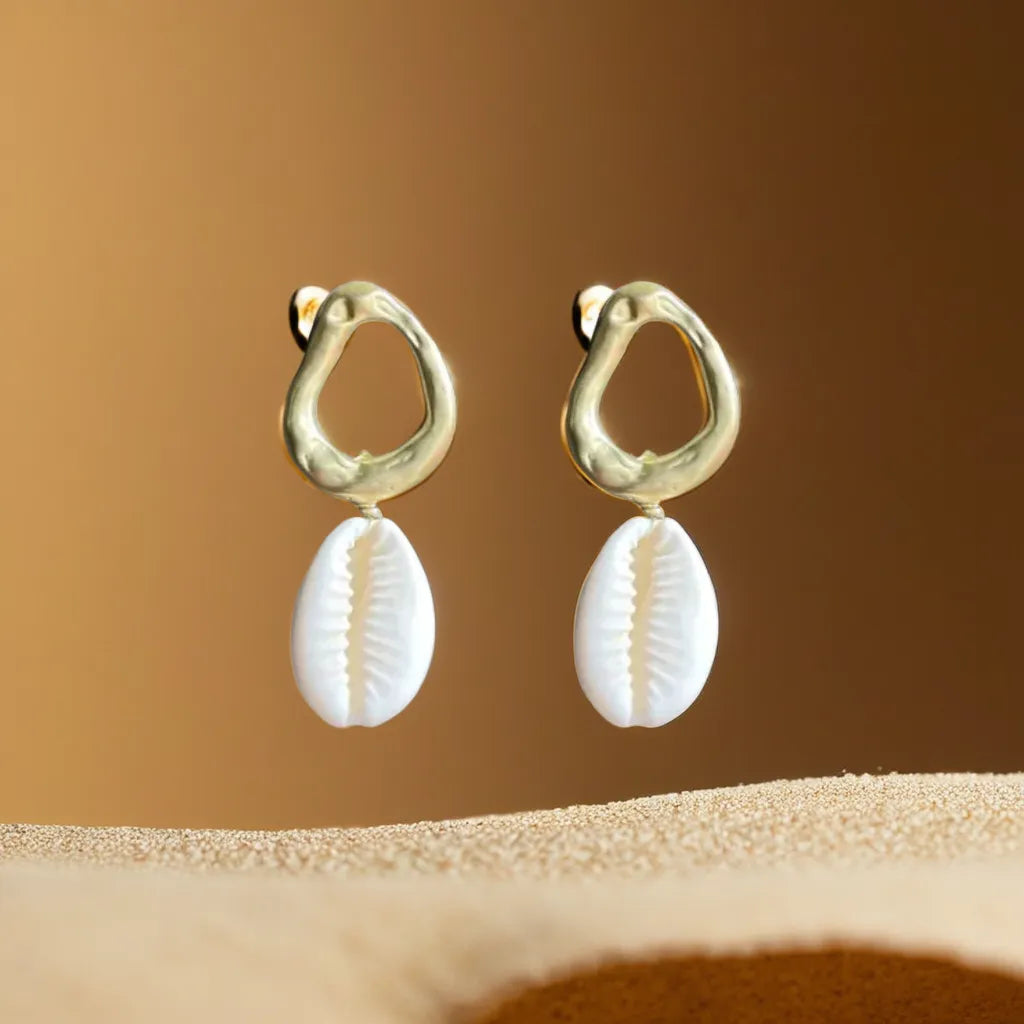 Women Gold Earrings – Cowrie Shell Hoops | Créoles Trésor de l’Océan

Embrace seaside charm with these women gold earrings featuring real cowrie shells and 18K gold plating. Lightweight, elegant, and made to shine.

Women gold earrings with cowrie shell – close-up on white background

Cowrie shell hoop earrings gold plated – coastal style jewelry

Créoles Trésor de l’Océan – gold shell earrings in natural light

Boho chic gold earrings for woman – beach-inspired design