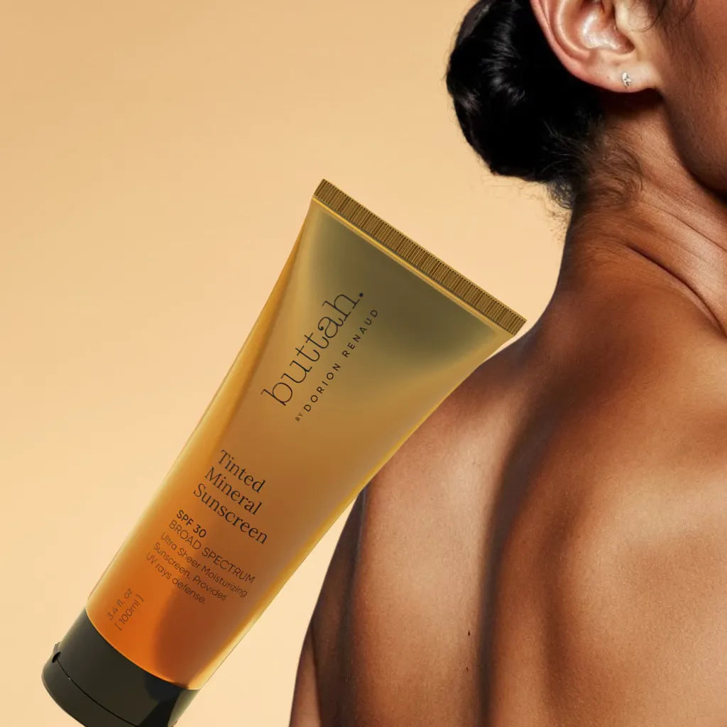 Invisible tinted sunscreen swatch on dark skin

SPF bottle with pump cap on neutral background

Sunscreen application on melanin-rich complexion

Matte finish skin after SPF application
