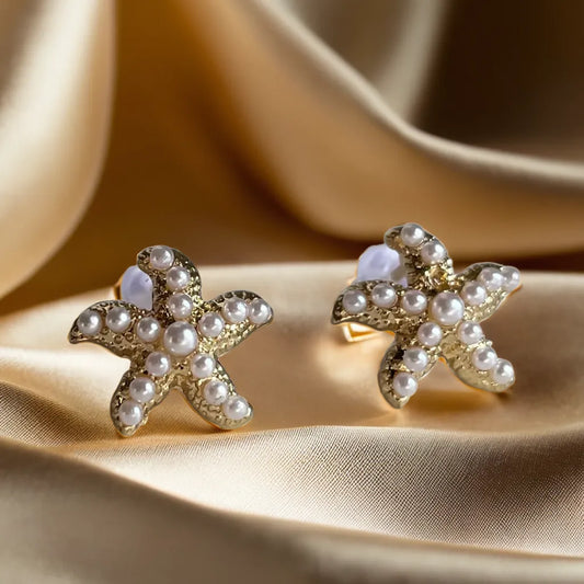 gold earrings women pearl starfish design

18k gold plated starfish earrings with pearls

tiny starfish earrings for woman close up

ocean-inspired pearl gold earrings women