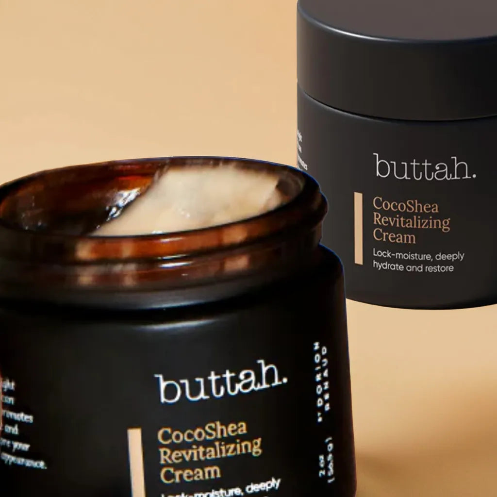 Jar of CocoShea Cream on a minimal shelf

Cream texture on fingertip, smooth and rich

Woman with melanin-rich skin applying cream to cheek

Close-up of hydrated, glowing skin after use